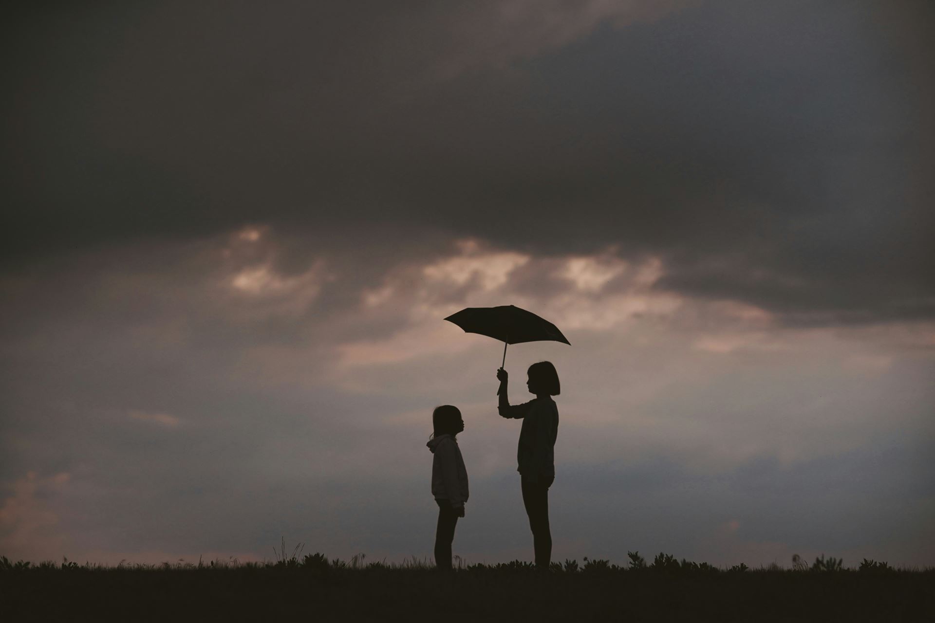 adult and child under umbrella